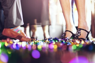 Close-up of feet at a party, colorful confetti on the floor, festive atmosphere, vibrant celebration, lively party scene, joyful gathering. New Year party celebration.