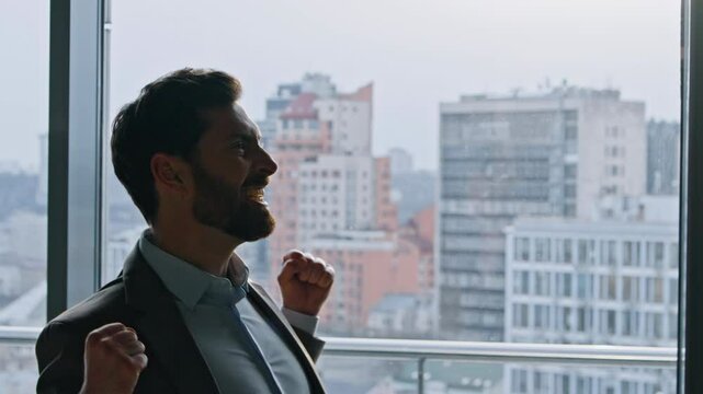 Cheerful founder celebrating contract raising arms in cityscape hallway closeup