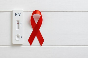 HIV Testing Kit with Red Awareness Ribbon on White Wooden Background for Health Awareness Campaign
