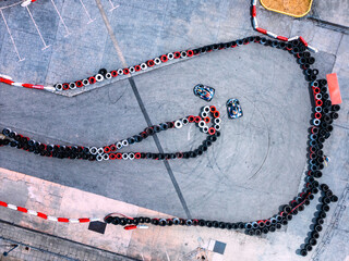 Exciting go-karting action on a winding outdoor track in sunny weather with colorful tires lined up...