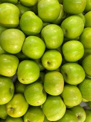 Fresh Green Apples Piled in Bulk – Close-Up Top View of Ripe Granny Smith Apples with Vibrant Color and Natural Texture for Healthy Food and Fruit Market Concept