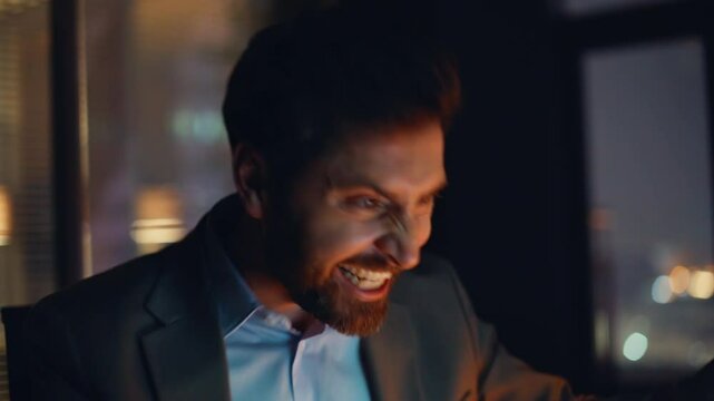 Surprised freelancer rejoicing success in laptop at evening office portrait
