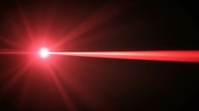 Vibrant red laser beam piercing through darkness, highlighting focused energy source