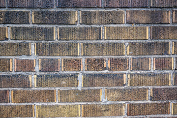 Close-up of a vintage textured brick wall with a mix of earthy tones and rough surface patterns. Ideal for backgrounds, architectural details, or design resources.