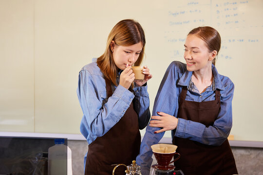 young barista woman making fresh coffee from machine and checking quality in the cafe
