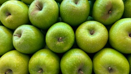 A close-up full frame shot of many vibrant green apples
