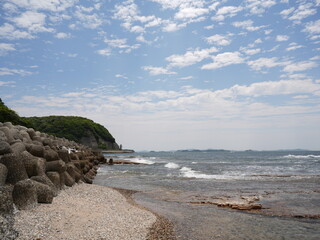 Rocky Japanese Coastline with Breakwaters and Blue Sky