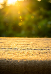 Textured Tablecloth in Sunlight: A close-up shot highlighting a rough-textured tablecloth, bathed in the warm embrace of sunlight, offers a perfect backdrop for showcasing product.
