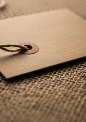 Vintage Tag on Texture: A close-up shot of a blank, vintage tag rests on a rough, woven surface, the details inviting attention and evoking a sense of classic style.