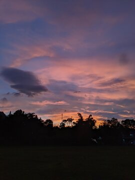 The beauty of sunrise on a field with mountains and clouds in the background