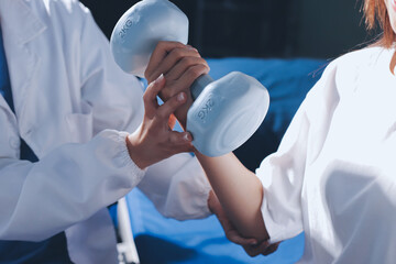 Unrecognizable uses blue hand weight during physical therapy session