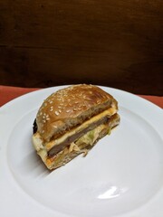 Mini burger on a white plate, with a wood and orange background