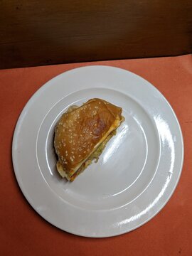 Mini burger on a white plate, with a wood and orange background
