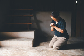 Female kneeling down praying for worship God at home. Christians pray to jesus christ for calmness....