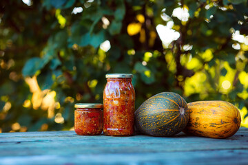 Home preservation. Vegetable salad in a glass jar on a wooden table. Natural green background with smooth bokeh. Healthy food concept. Vegetables from the garden.