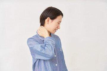 パジャマ姿の女性　寝違え　白背景