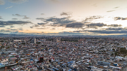 Stunning Aerial View of Bogotá at Sunset with Urban Landscape and Mountainous Background