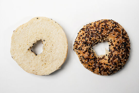 Closeup view of slice of bagel breads with sesame seeds isolated over white background. Top and middle part. Top view