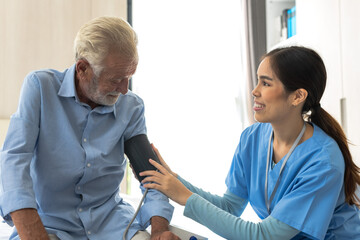 Obraz premium Female caregiver taking care of elderly Caucasian man in senior home care