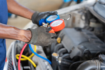 Close up of Mechanic Hand with AC Refrigerant Manifold Gauge Set Repair Car Air Conditioning in Workshop, Technician Check Car Air Conditioning System Refrigerant Recharge