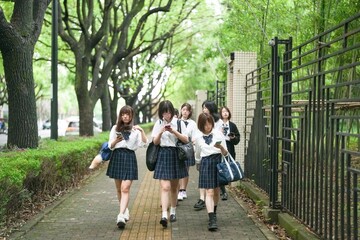 In early June in Pudong, Shanghai, seven Japanese high school girls in summer uniforms walk...