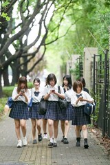 In early June in Pudong, Shanghai, seven Japanese high school girls in summer uniforms walk...