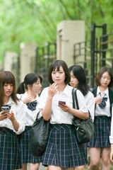 In early June in Pudong, Shanghai, seven Japanese high school girls in summer uniforms walk...