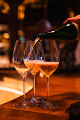 wine-sparkling-champagne-pouring-into-glass-wooden-bar