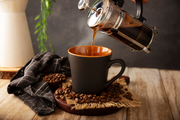 Coffee cup and a French press, also known as a piston coffee maker or French coffeemaker, is a simple device for preparing hot coffee.