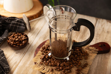 Roasted and ground coffee in a French press..French press, also known as a piston coffee maker or French coffeemaker, is a simple device for preparing hot coffee.