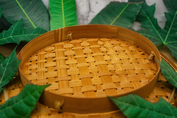 A meticulously woven round bamboo tray, highlighting its natural texture and artisanal appeal,...