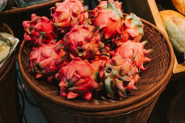 Red ripe pitahaya in a basket near the counters in the supermarket. Delicious exotic fruits in the grocery store.