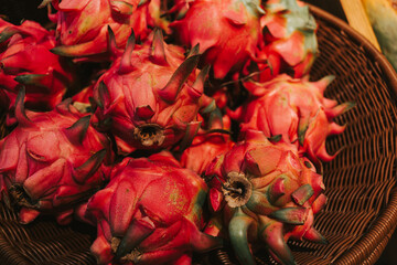 Red ripe pitahaya in a basket near the counters in the supermarket. Delicious exotic fruits in the grocery store.