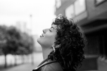 Young woman breathing fresh air in urban environment, grainy analog photo