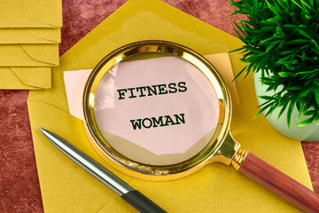 Motivational phrase FITNESS WOMAN through a magnifying glass on a note from an envelope