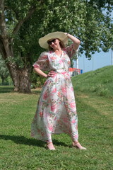 Portrait of the mature woman with hat standing in the park