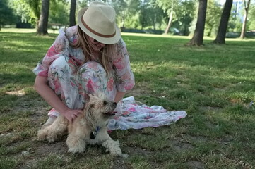 Mature woman with cute little dog in a park