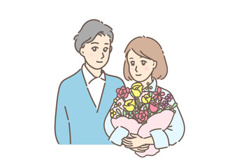 素敵な花束を抱える若い女性と寄り添う男性。記念日を祝う夫婦・カップル。
