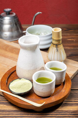Matcha green tea with a traditional bamboo brush whisk and a spoon on a table. Accessories for making matcha green tea