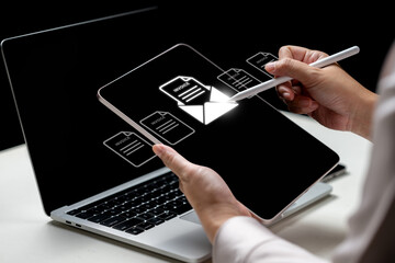 Fototapeta na wymiar Businesswoman using a tablet with an invoice and mail icon. Laptop on the table. Technology innovation on a virtual screen. Concept of E-invoice and online digital statements