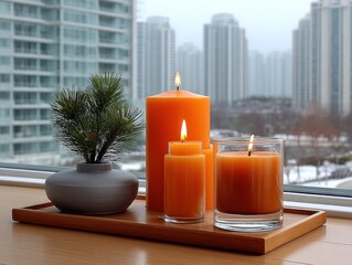 Orange candles on a tray by window