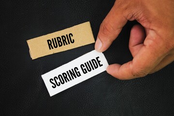 Square paper with the words Rubric and Scoring Guide. A rubric and a scoring guide are both assessment tools, but a rubric is a more structured approach