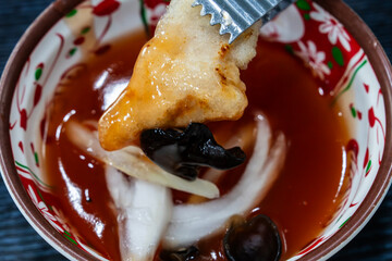 dipping fried pork into the sweet sauce