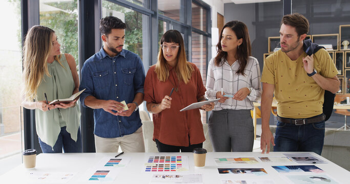 Business people, cooperation and tablet with planning, creative project and brainstorming with app. Internet, employees and graphic designers in workplace, feedback and tech with color for proposal - Powered by Adobe