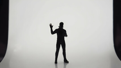 Person silhouetted against a bright background conveys a sense of greeting and connection in an artistic portrayal of human emotions