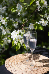 Sparkling drinks served on a woven mat amidst blooming white flowers