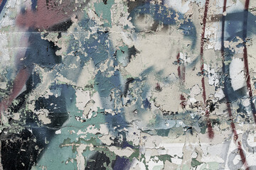 Abstraction of crumbling graffiti on a city street wall. Colorful abstract background. Old, cracked, peeling paint on the wall as a background.Abstract background in neutral calm colors.