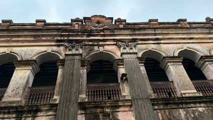 Fototapeta premium Distorted Perspective of Old Colonial Building with Arches and Decorative Ironwork Balconies
