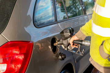 Driver fills the gas tank of a car at gas petrol station as essential task of the travel routine, ensuring the car is ready for the day's commuting needs