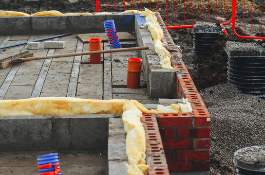 Insulating walls of new build houses by placing rock wool inside wall cavities as part of the energy-saving measures. House insulated with mineral wool to reduce energy bill